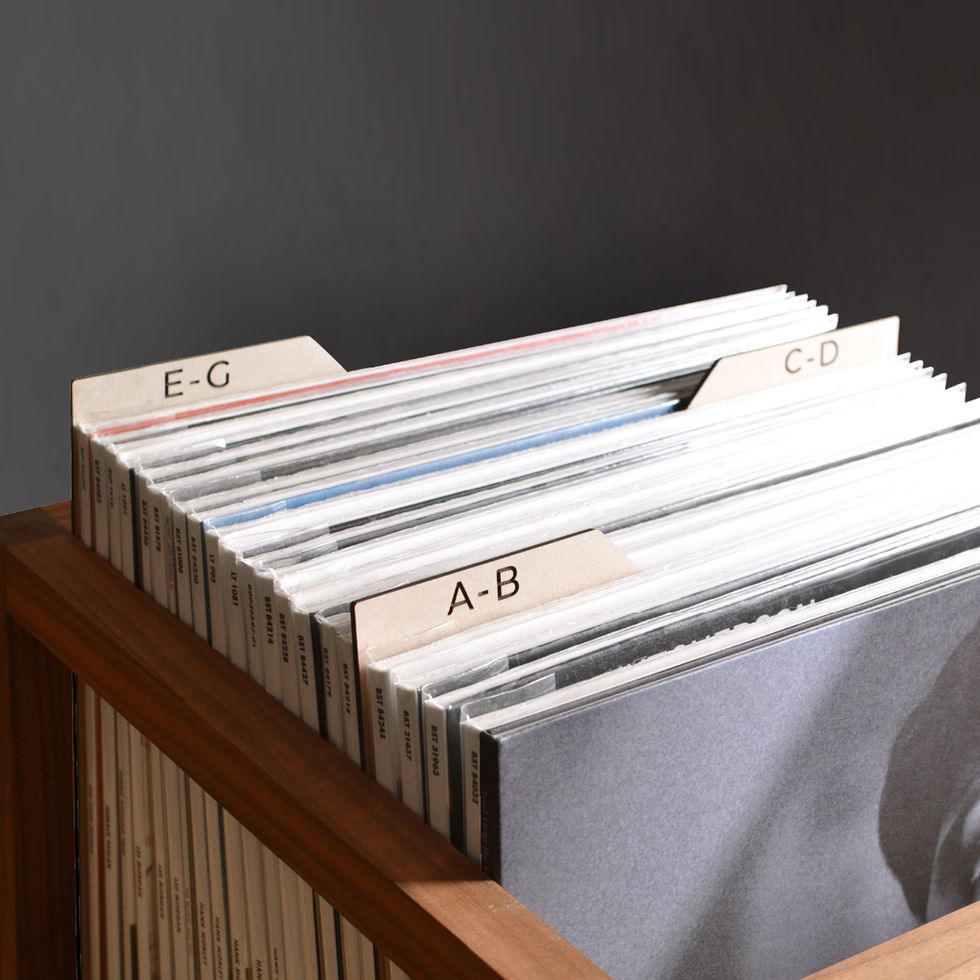 vinyl record dividers with laser-engraved custom alphabetical titles separating records inside a minimal solid walnut record