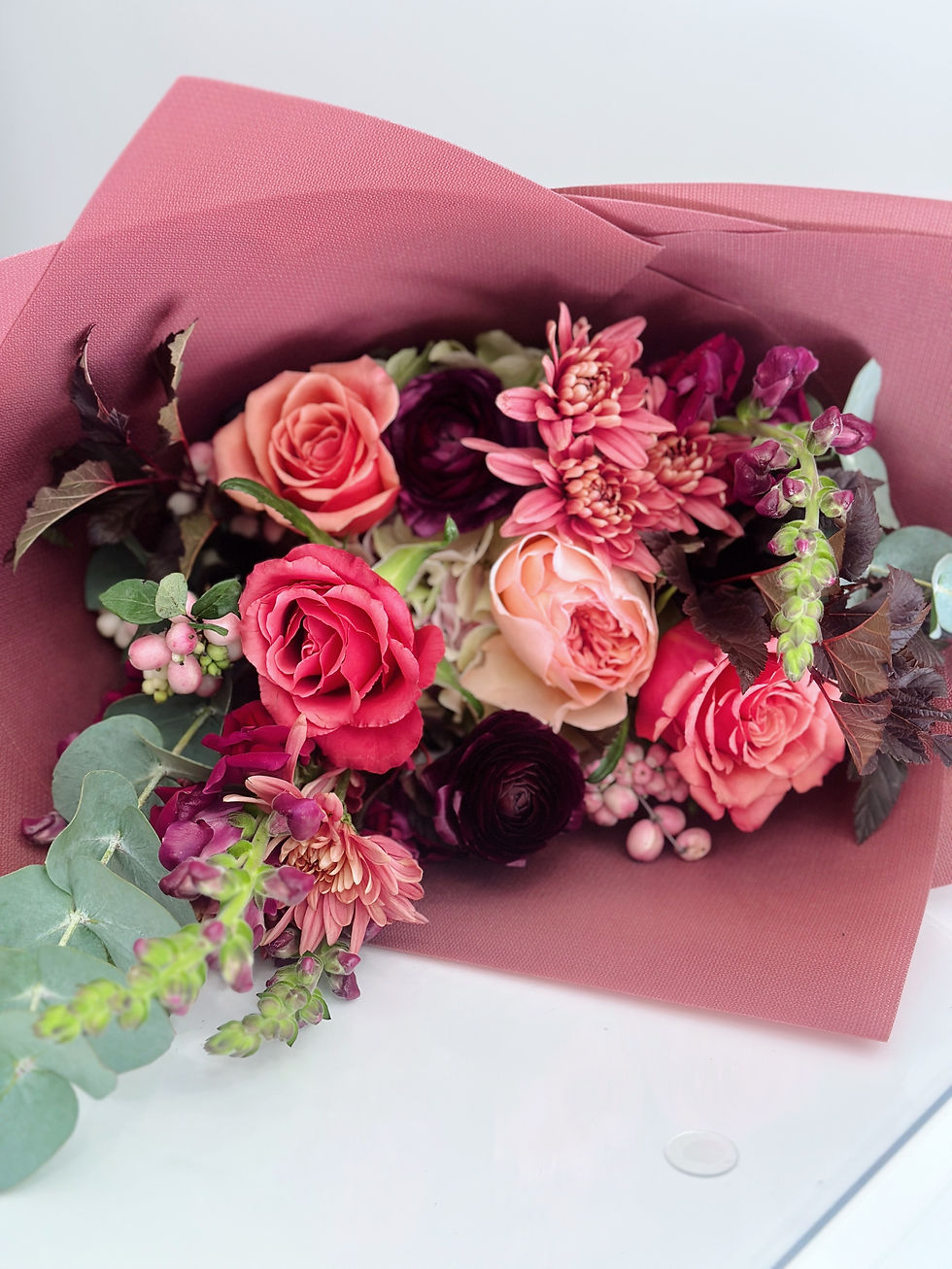Elegant hand-tied flowers with textured blooms and airy greenery, ready for gifting.
