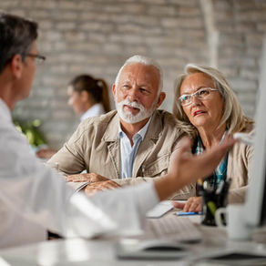 Older couple discussing medical records with a doctor during a longevity consultation