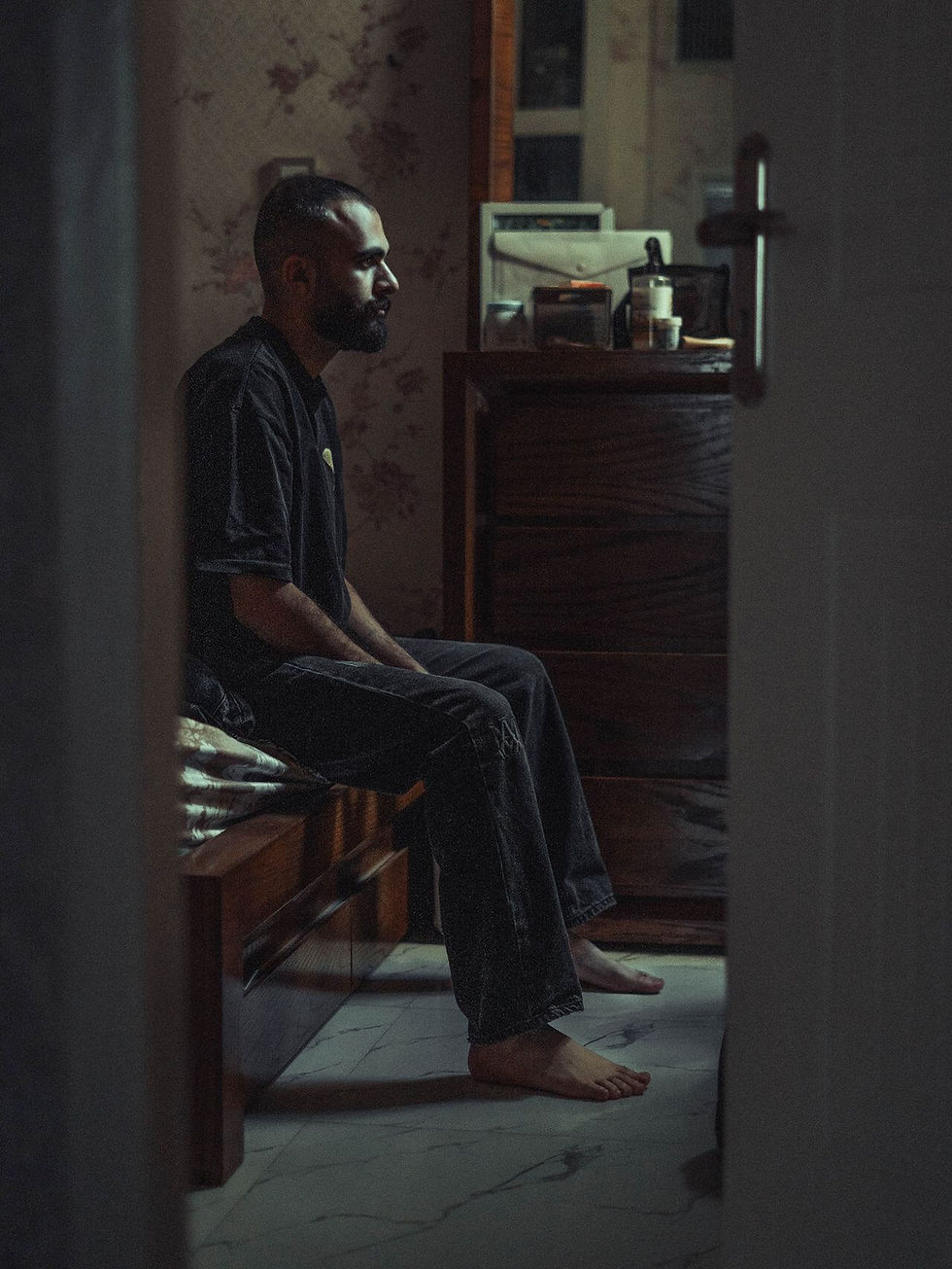 Man sitting alone while experiencing low mood and reflecting on his alcohol use