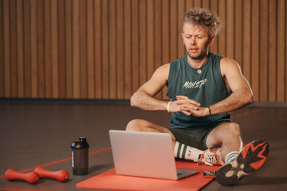 Aspiring personal trainer studying an online CPT course beside fitness equipment.