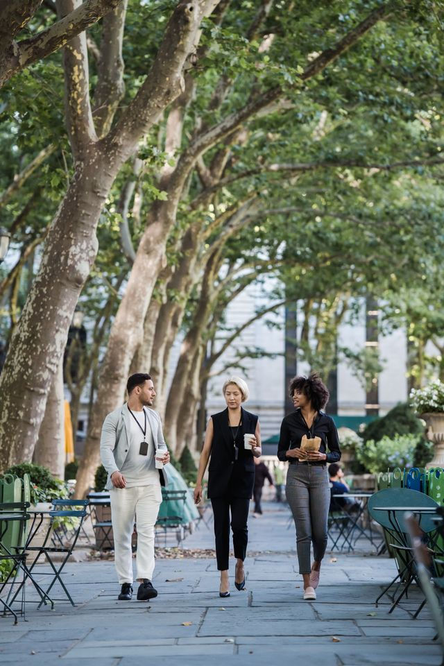 Colleagues walking through a park together during a lunch break