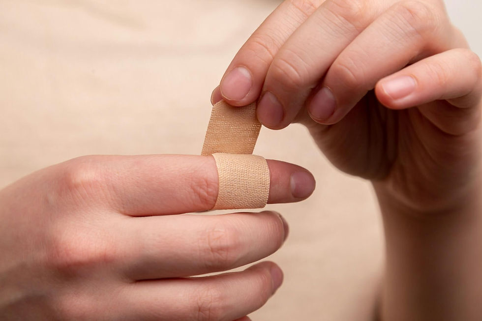 Close-up of hands carefully wrapping a finger with a beige bandage, illustrating attentive care in a multidisciplinary therapy setting.