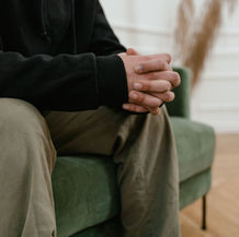 Man sitting in a therapy setting while considering gender-specific addiction treatment.