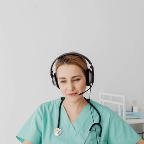 Remote healthcare assistant wearing a headset while communicating through a laptop