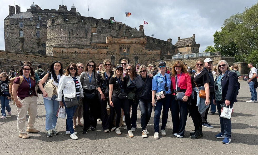 A group of travel advisors stand in front of Edinburgh Castle