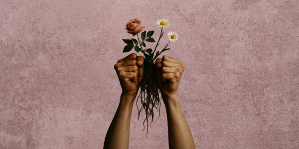 duas mãos sujas de punhos cerrados com flores e raízes no seu meio