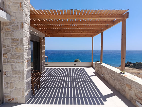 Natursteinhaus auf Kreta mit Pergola und Meerblick als Beispiel für hochwertigen Hausbau.