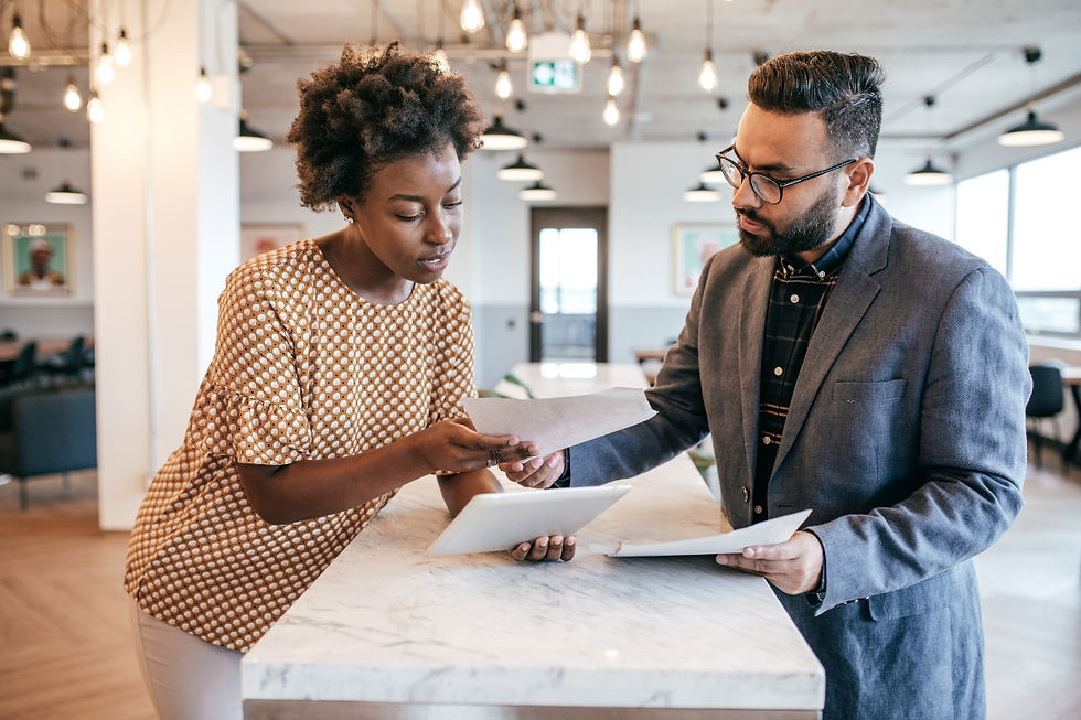 A travel agent and a client are looking at some documents in an office