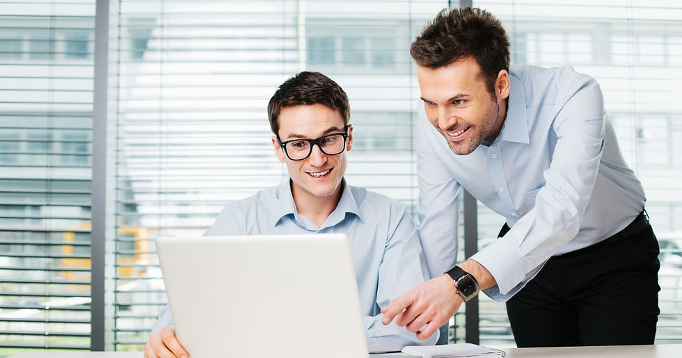 Two people working on a laptop in an office