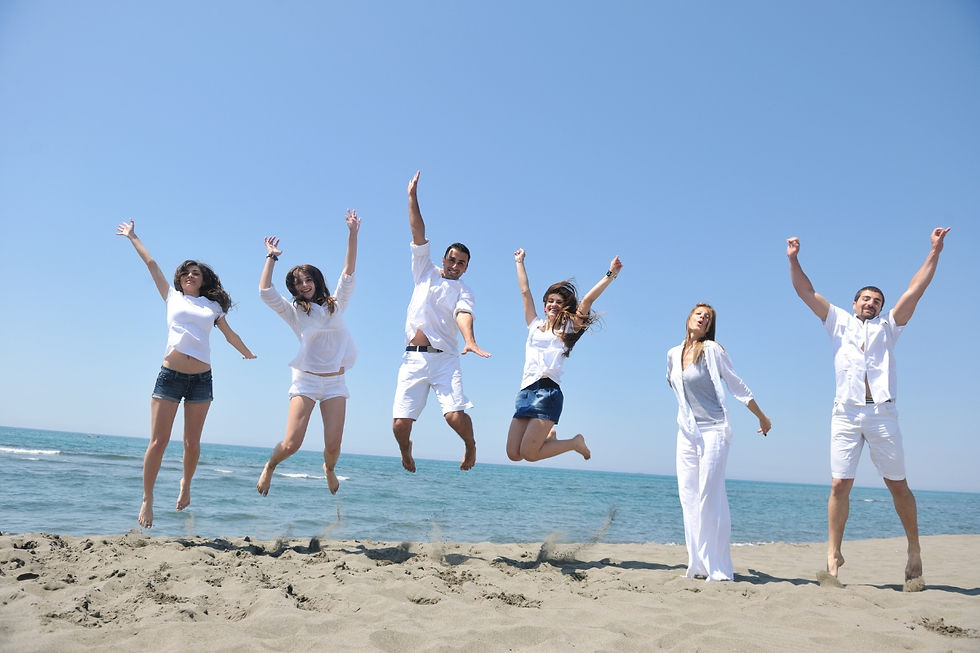 A group of travelers jumping in the air on a beach