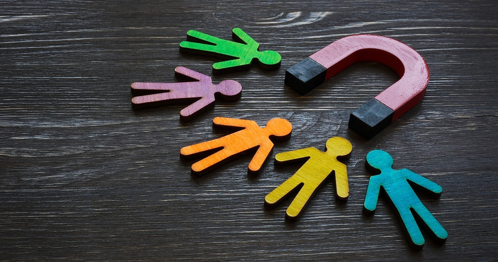 Colorful people standing around a magnet on a wooden table