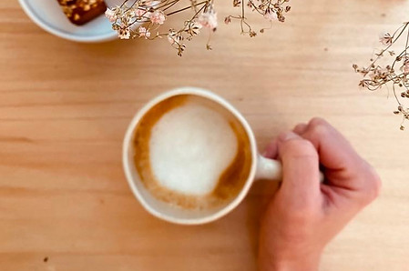 une tasse de café latte avec une main