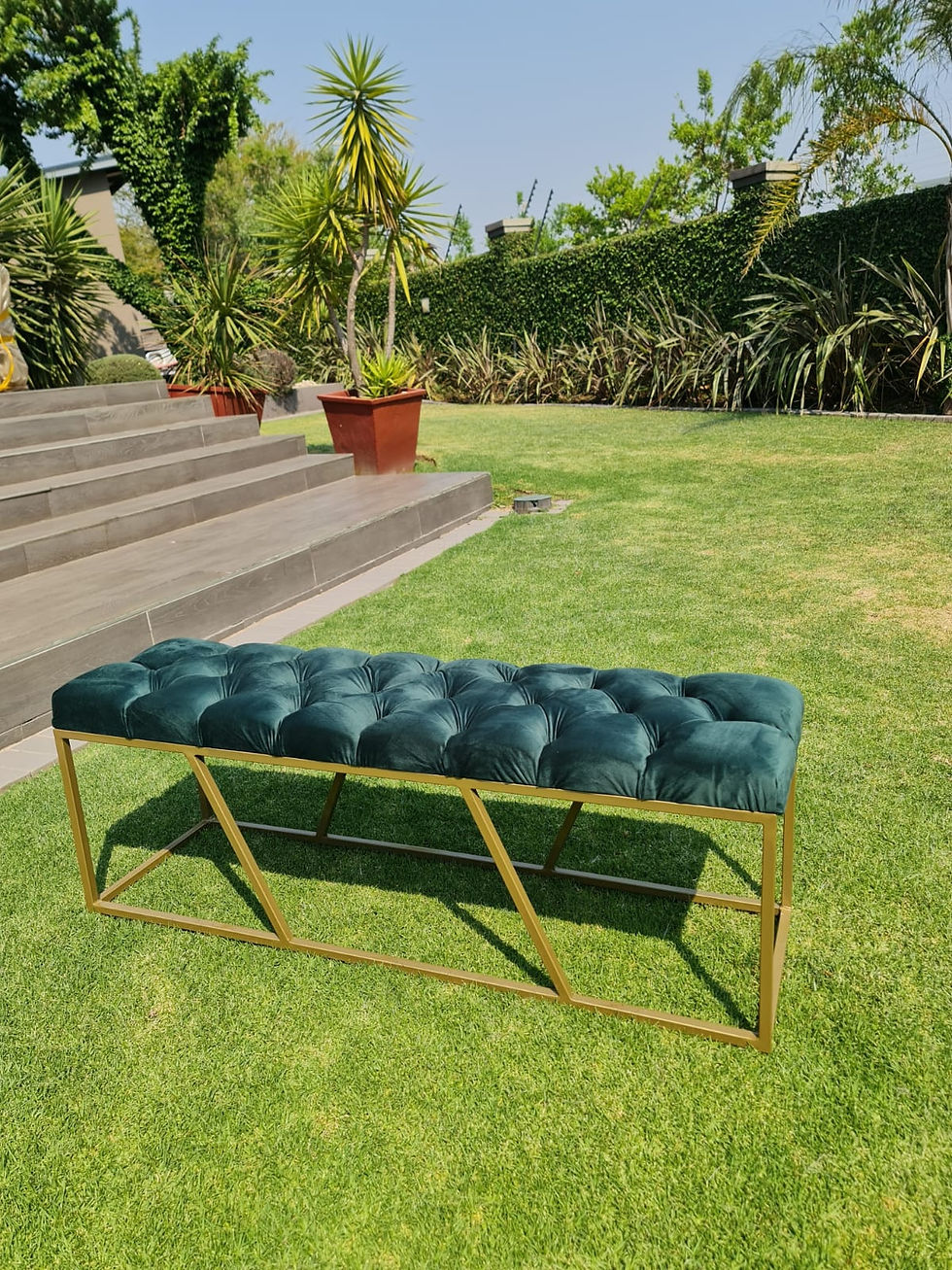 Green velvet bench with gold frame on green grass background