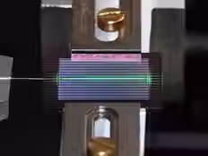 The experimental setup shown here incorporates on-chip optical parametric oscillator (OPO) technology to generate a frequency comb of laser-like light covering a wide range of frequencies with very little input energy. In this image, the chip includes ~20 OPOs, and one of them is being tested. An optical fiber is shown to the left of the chip and a free-space objective to the right. Credit: Alireza Marandi