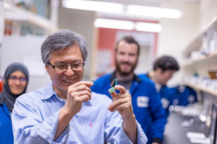 Dr. Kyeongjae Cho, professor of materials science and engineering, displays the finished battery and the hardware used to test its efficiency. Cho is director of the Batteries and Energy to Advance Commercialization and National Security (BEACONS) center. @ The University of Texas at Dallas