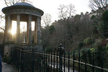 Sonnenuntergang hinter einem im altgriechischen Stil erbauten kleinen, runden Tempel