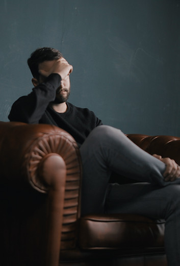 Thinking Man on Couch who needs to attend a session of individual counseling in Marietta, GA