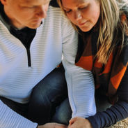 Engaged couple with a ring holding hands.