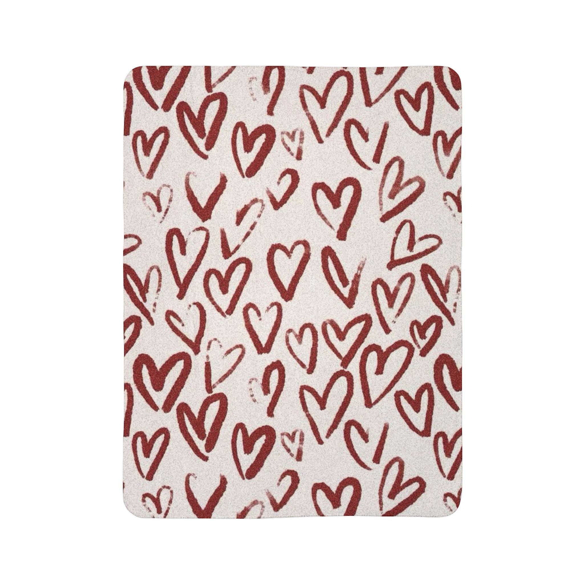 Sherpa fleece blanket with a soft double-sided texture and hand-drawn heart pattern in warm muted red.