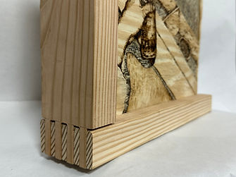 Closeup shot of a plywood carving art piece with a look at the pine wood frame built using finger joints
