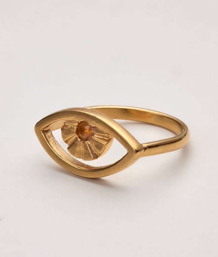 ing is designed in the shape of an eye, crafted from 925 sterling silver and plated with 24-carat gold for a radiant, luxurious finish. At the center of the eye, a genuine garnet gemstone adds a deep, rich touch of color, symbolizing passion and strength.