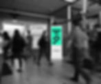 Digital advertising screen inside lobby crowd in the foreground