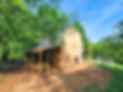 wooden barn on a farm with picnic table and solar panels surrounded by woods