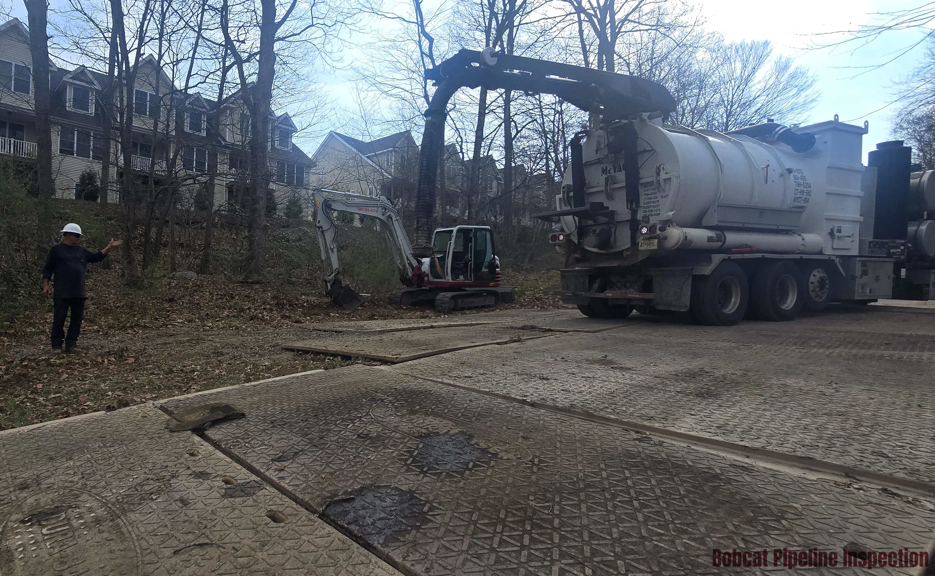 A spotter assisting the driver of a hydrovac truck with safe positioning.