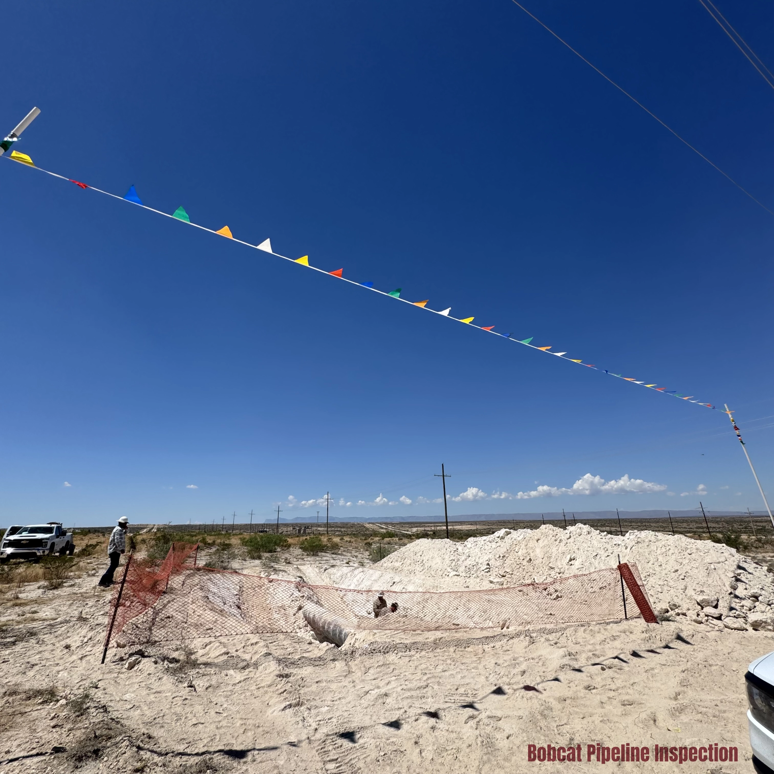 Obstacles and dangers such as powerlines flagged for safety on a pipeline project site.