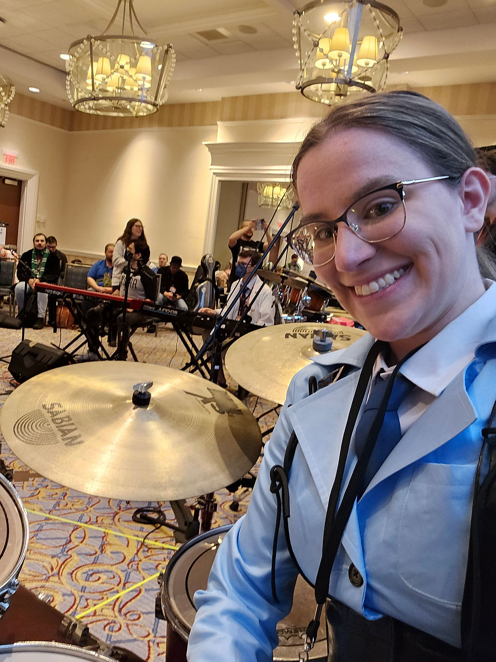 Selfie of a Medic cosplay behind a drum kit