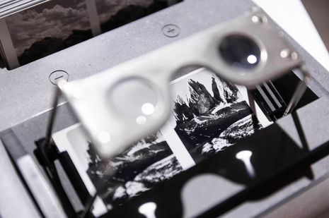A close-up look through a vintage Zeiss stereo-viewer's lens shows a mountain image.