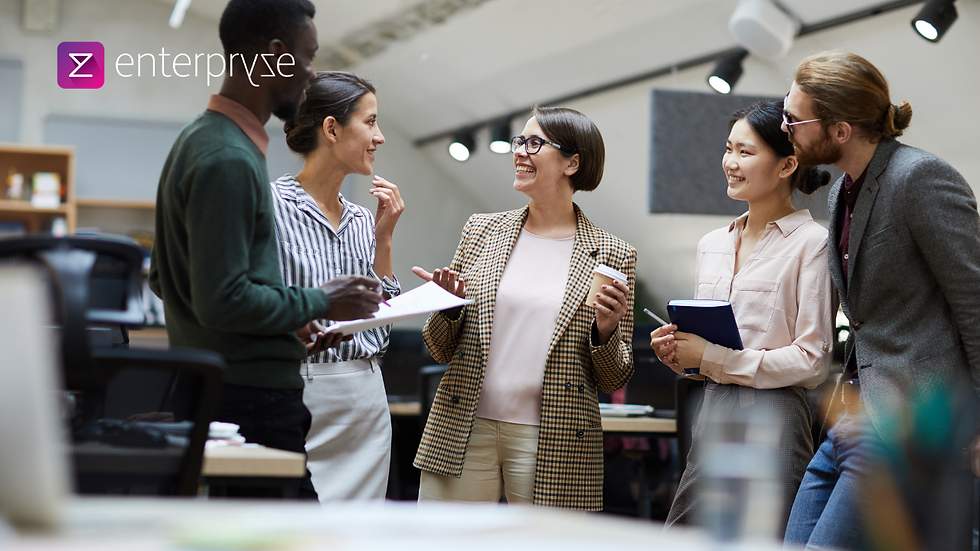 Five people in an office, smiling and chatting. One holds a cup, another with a notebook. "Enterpryze" logo visible. Bright, modern setting.