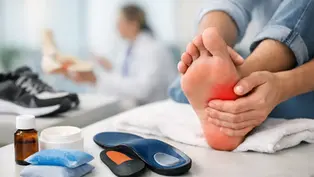 Gloved clinician uses a handheld device with blue light on a patient’s heel in a clinic, suggesting painless foot therapy