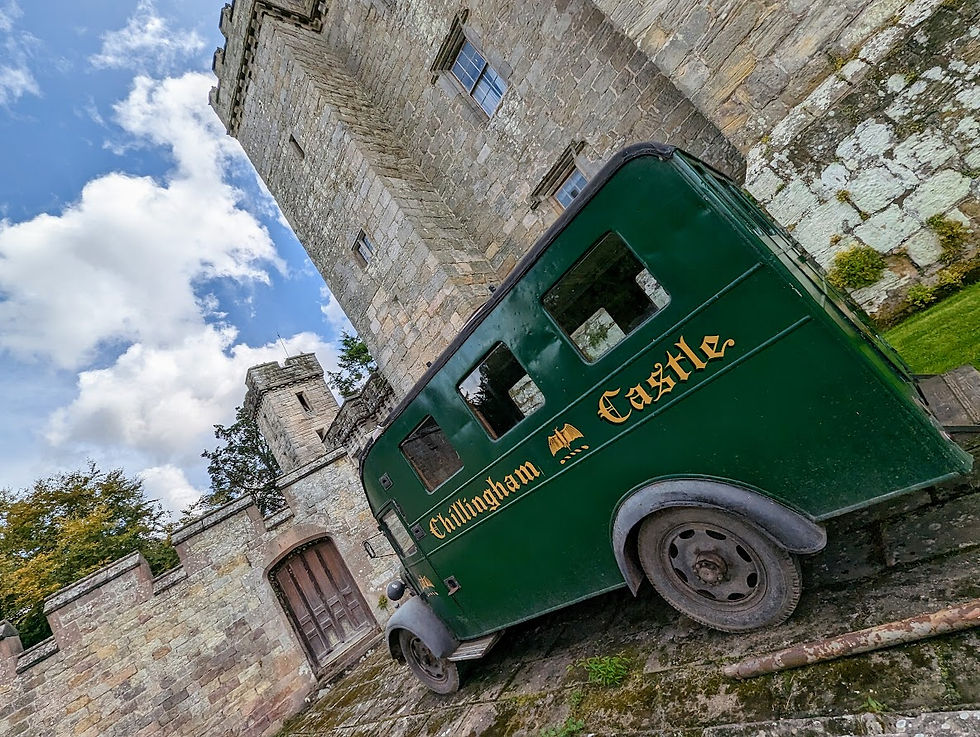 An old fashion 1920 style green minibus van outside of Chillingham Castle