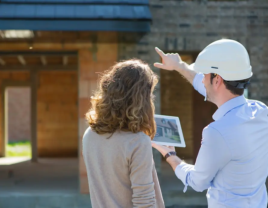 Legacy Glass Block & Window Co. consultant reviewing project design plans on a tablet with a homeowner at their residence in Will County.