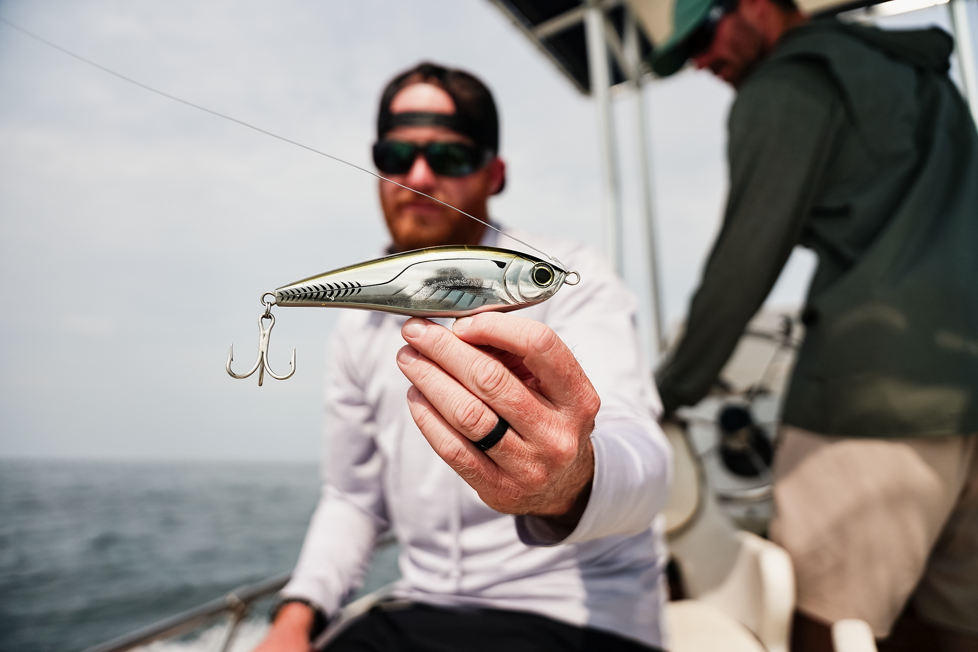A fisherman holding up a Yo-Zuri Twitchbait fishing lure.