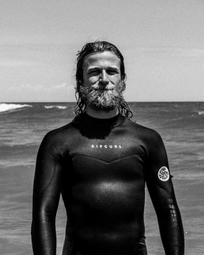 A portrait of a surfer in a wetsuit.