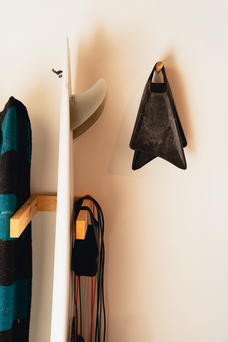 a surfboard and swim fins hanging on the wall.
