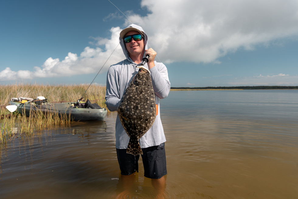 fisherman holding a trophy size flounder.