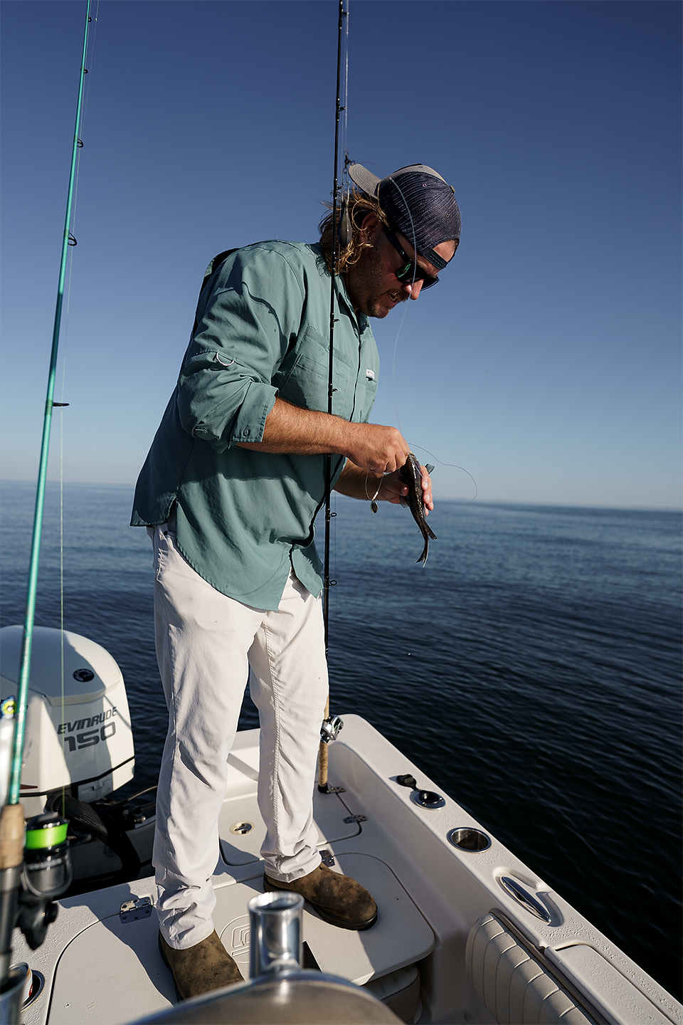 a fisherman unhooking a black seabass.