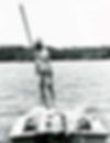 A fisherman using a pole to push a flats skiff.