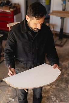 a woodworker holding a white template.