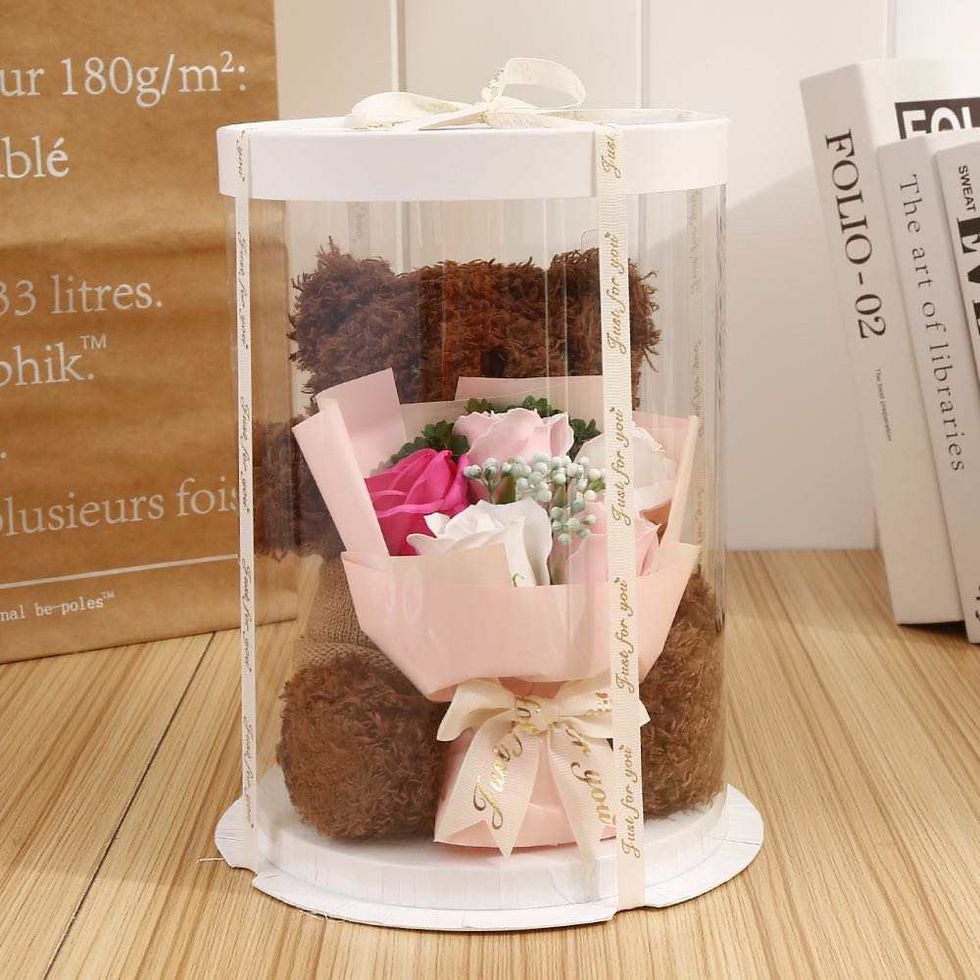 Thumbnail: Teddy bear in clear gift box holding mini bouquet, sweet add-on for floral gifts with Medford NJ florist delivery