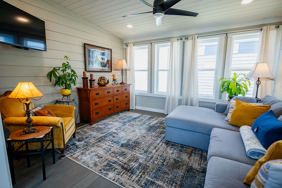 Sunny tiny home living room with eight windows, a sofa and a dresser