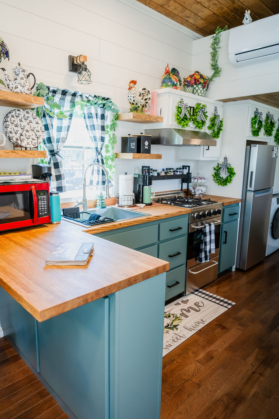 Tiny home kitchen with full size appliances and a window over the sink