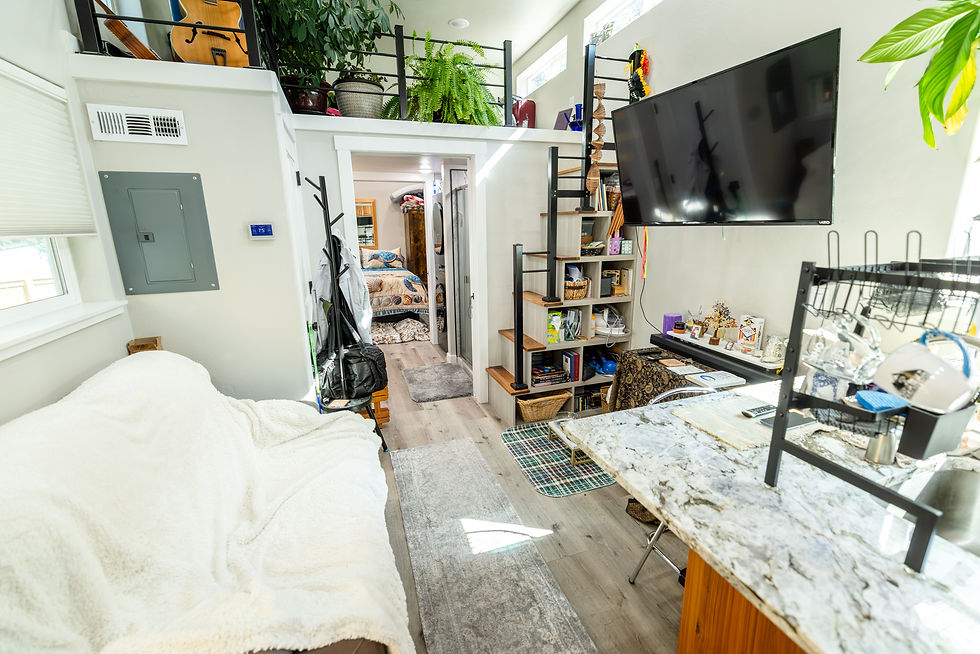 Tiny home living area with a vaulted ceiling, two reclining chairs and a large window