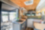van conversion bedroom with rounded cabinets and Maxxair fan