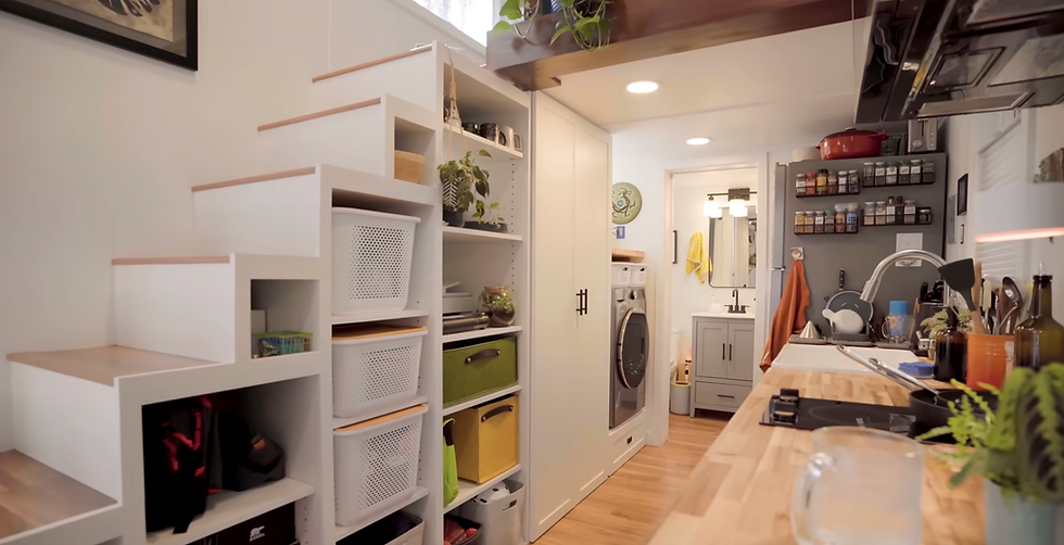 Space-saving tiny home staircase with built-in storage next to the kitchen.