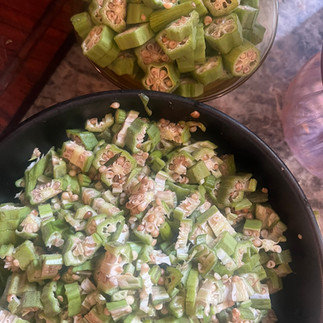  Photograph showing freshly cut okra prepared in two forms: larger sliced rounds revealing seed structures and finely chopped pieces prepared to increase draw throughout the soup.